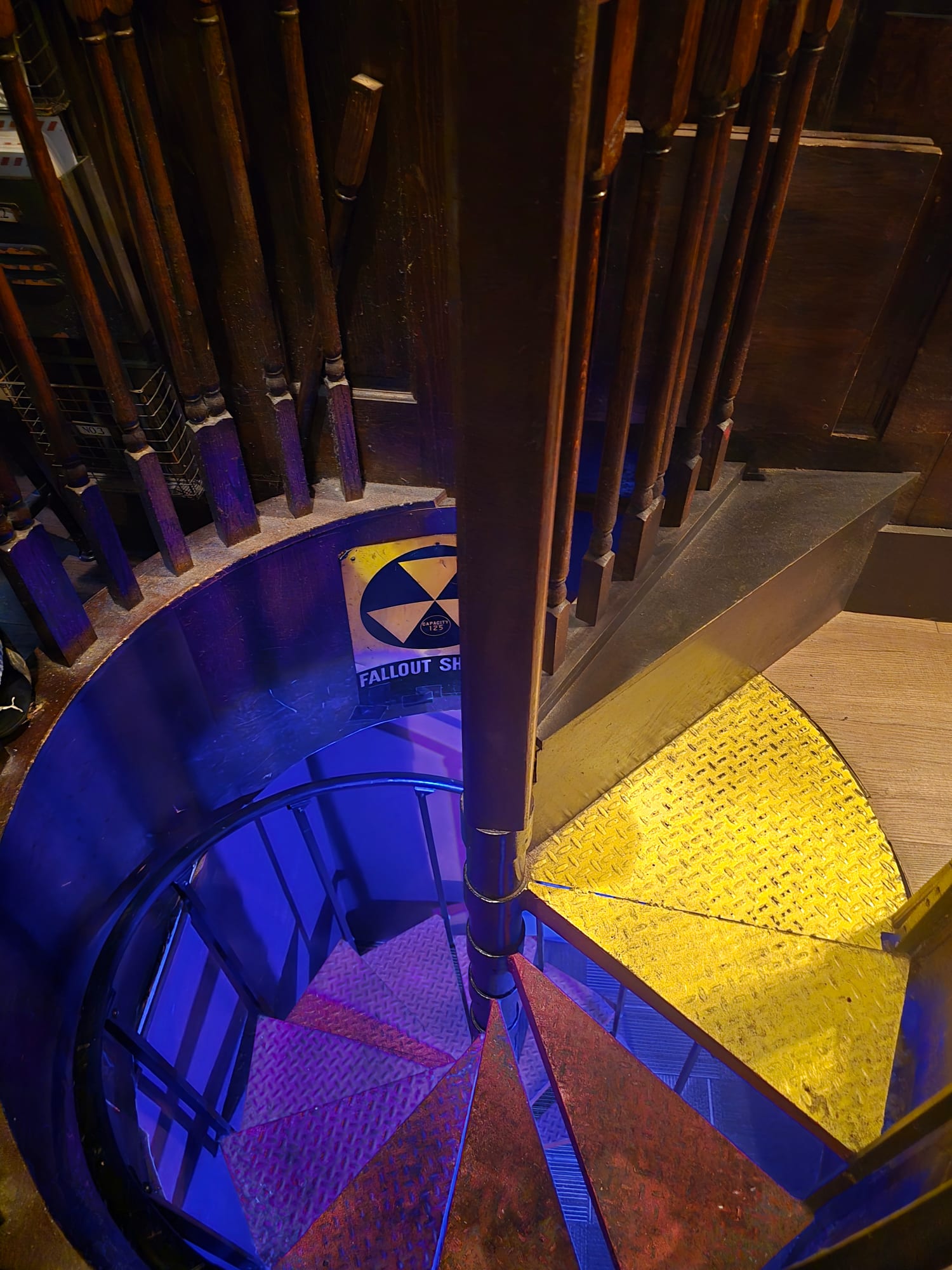 spiral staircase with a fallout shelter sign
