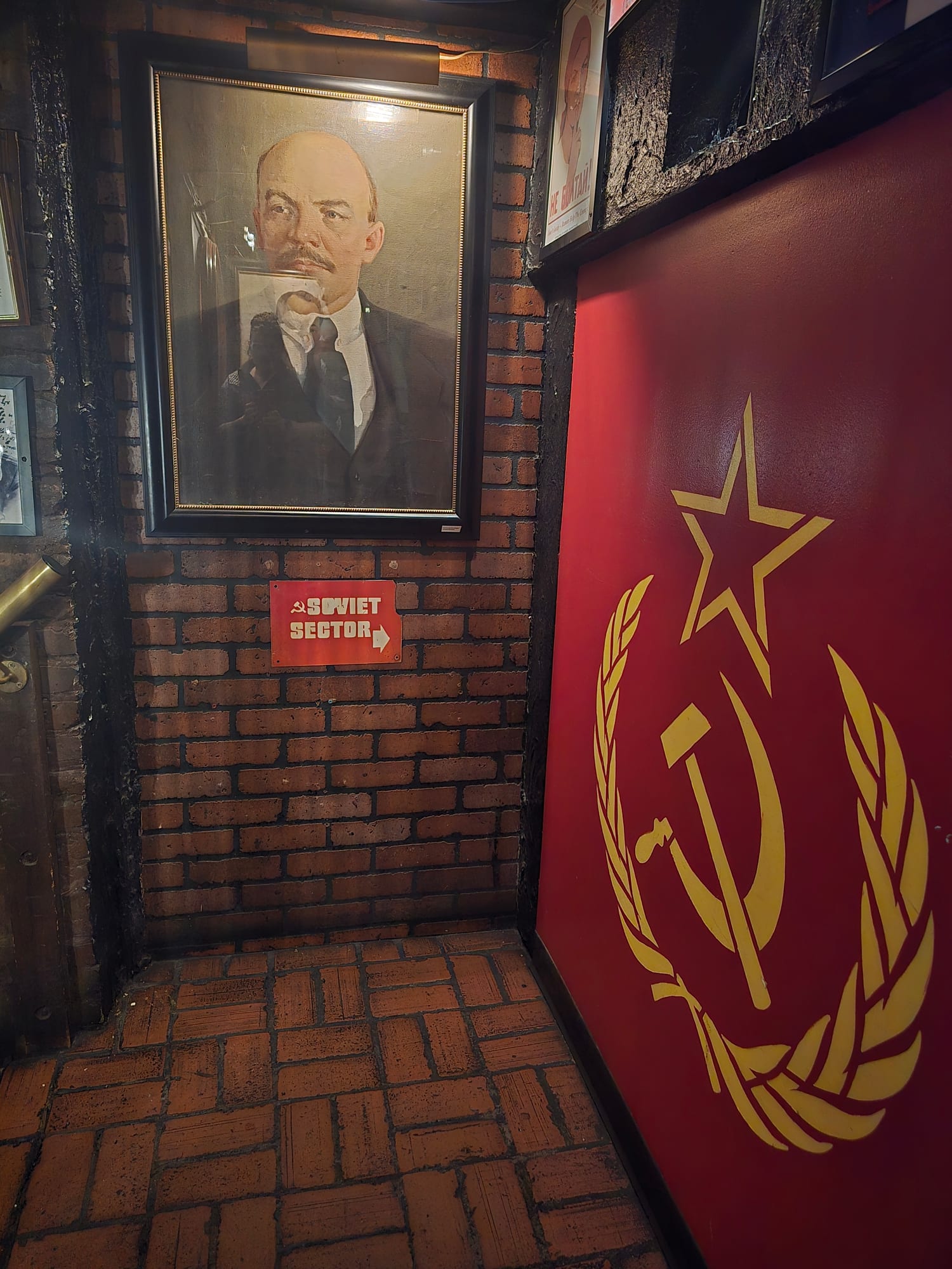 wall with large USSR symbols and a sign pointing to the Soviet sector